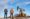 Group of oil workers standing on an oil field near a pump jack during daytime.