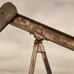Close-up of a rusted oil pumpjack arm with worn-out metal structure.