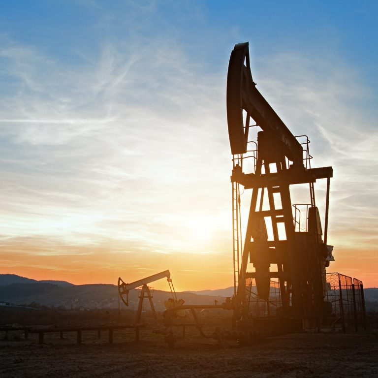 Oil pumps. Oil industry equipment. Oil rocking at sunset