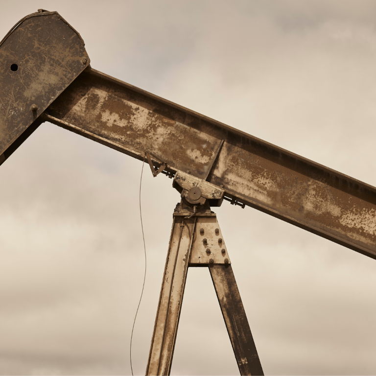 Close-up of a rusted oil pumpjack arm with worn-out metal structure.